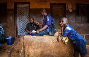 Senbha Bangura (vas.) ja Santigie Bayo Dumbuya (keskellä) iloitsevat uudesta koulurakennuksesta George Brooksin slummissa Freetownissa. 