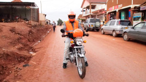 Joseph Ssembusa pukeutuu muiden SafeBodan kuljettajien tavoin oranssiin liiviin. ”Nyt tunnen olevani joku, en pelkkä satunnainen bodakuljettaja”, hän sanoo.
