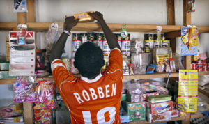 Poika siivoaa kaupan hyllyjä Gaossa Malissa, joka on monen länsiafrikkalaisen siirtolaisen pysähdyspaikka matkalla Eurooppaan. Moni poika unelmoi pelaavansa ammatikseen jalkapalloa, kuten hollantilainen Arjen Robben. Sven Torfinn/Panos