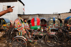 Shahbuddin Mondol tog sig till Dhaka då flodvattnet översvämmade marken där hans hus stod. Nu bor han på ett tak tillsammans med femtio andra rickshawförare.