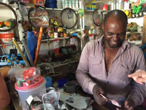 Arushalainen kioskiyrittäjä Hassan Yusuf Macha lataa aurinkoenergialla asiakkaidensa matkapuhelimia ja jäähdyttää pakastinta. Kylmästä juomasta voi veloittaa enemmän kuin lämpimästä.