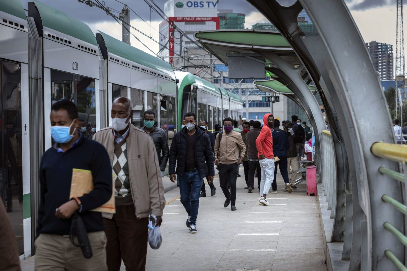 Suojamaskeihin sonnustautuneita miehiä kävelee juna-aseman laiturilla Etiopian pääkaupungissa Addis Abebassa.