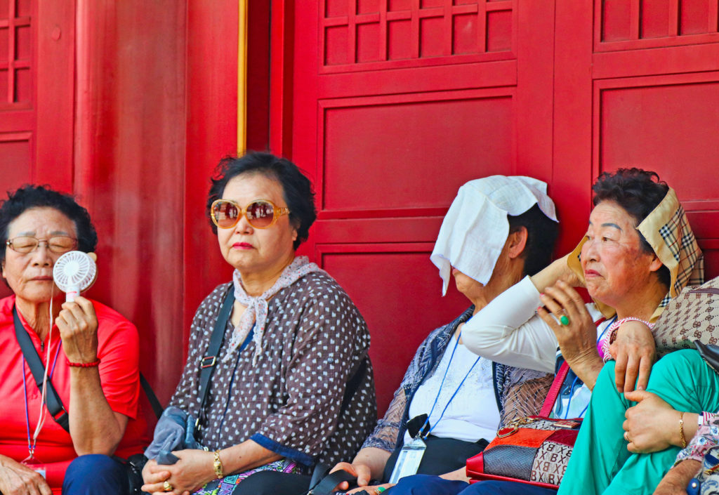 Neljä kiinalaista vanhaa naista vilvoittelevat helteessä.
