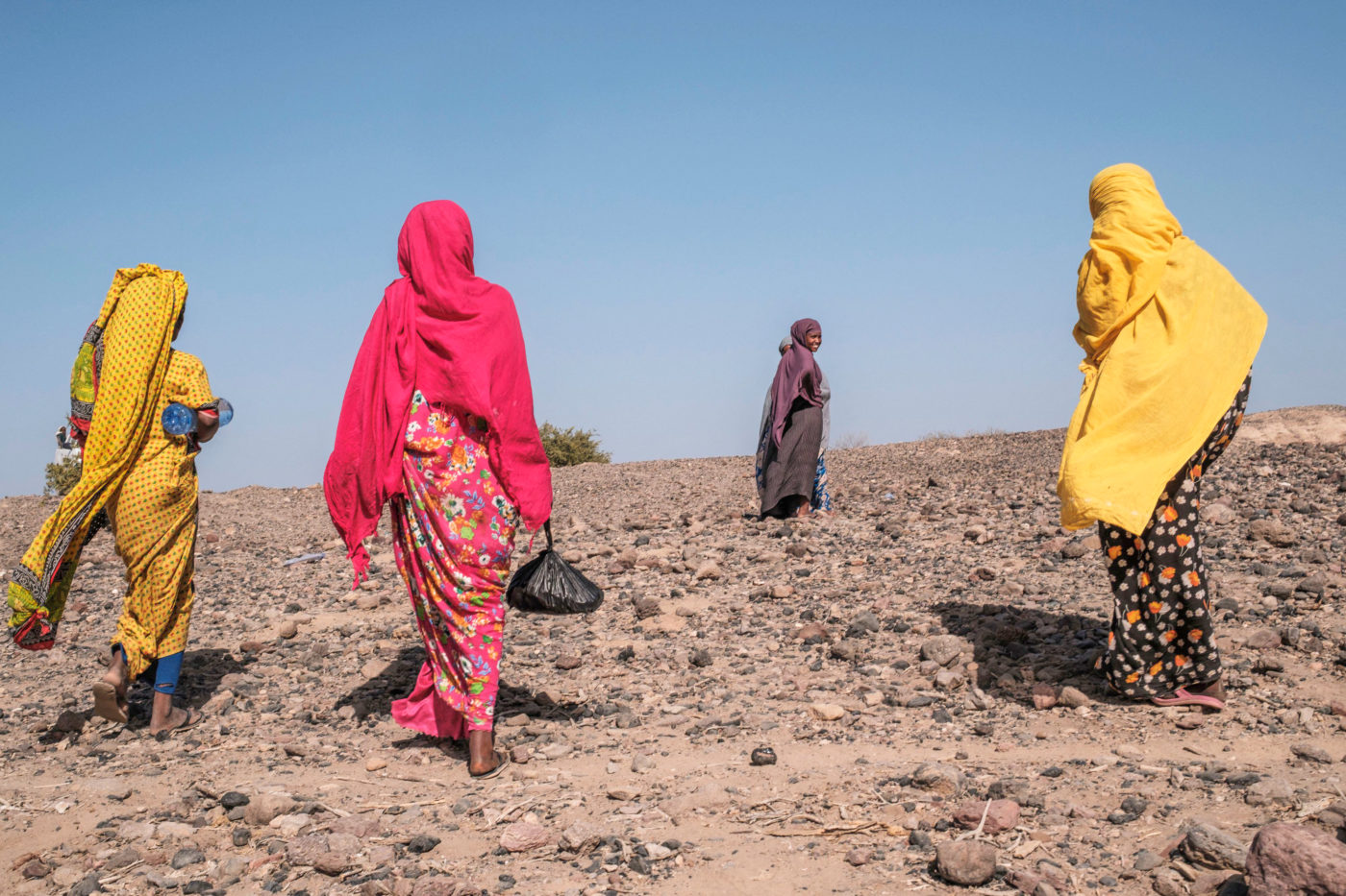 Naisia kävelemässä kuivalla maalla.