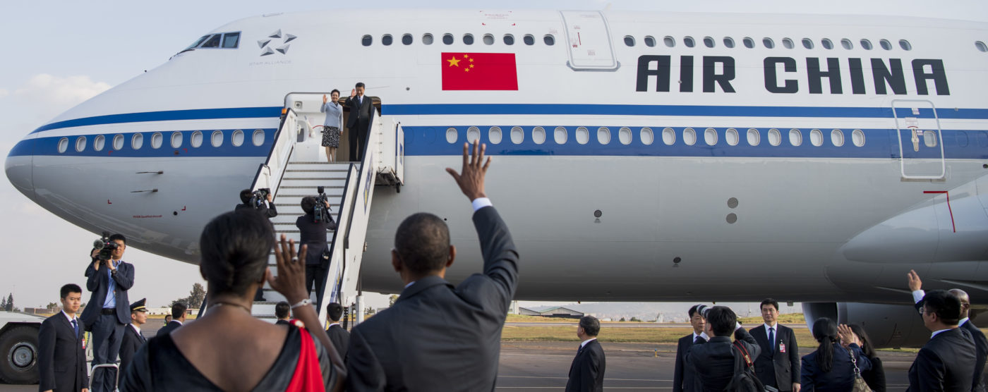 Lentokoneesta astuu Kiinan presidenttipari, etualalla mies ja nainen tervehtivät heitä selin kameraan.