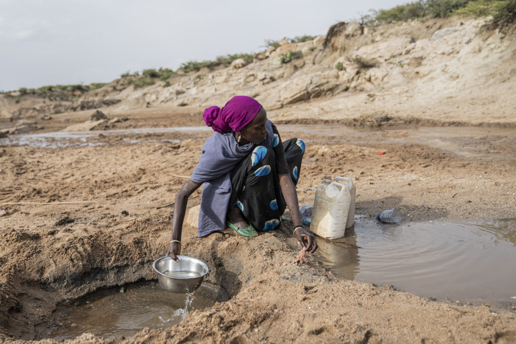 Etiopialainen nainen kauhoo vettä.