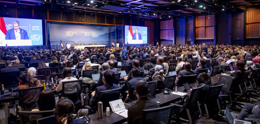 COP27-huippukokouksen sali, jossa suuri joukko kuuntelee puhujaa lavalla