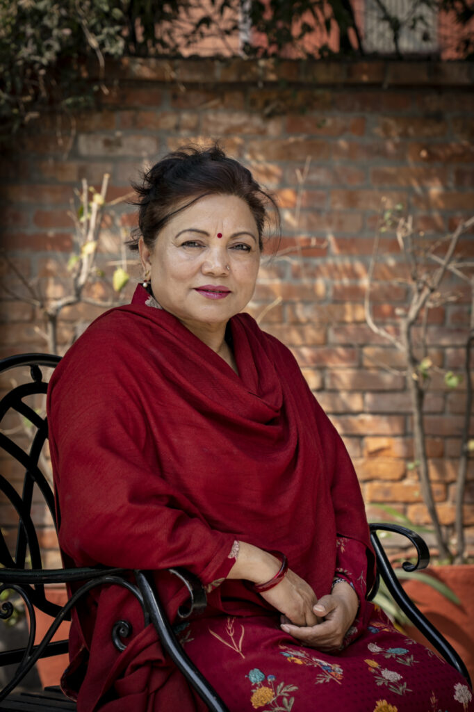 Durga Sob istuu penkillä ja poseeraa kameralle.