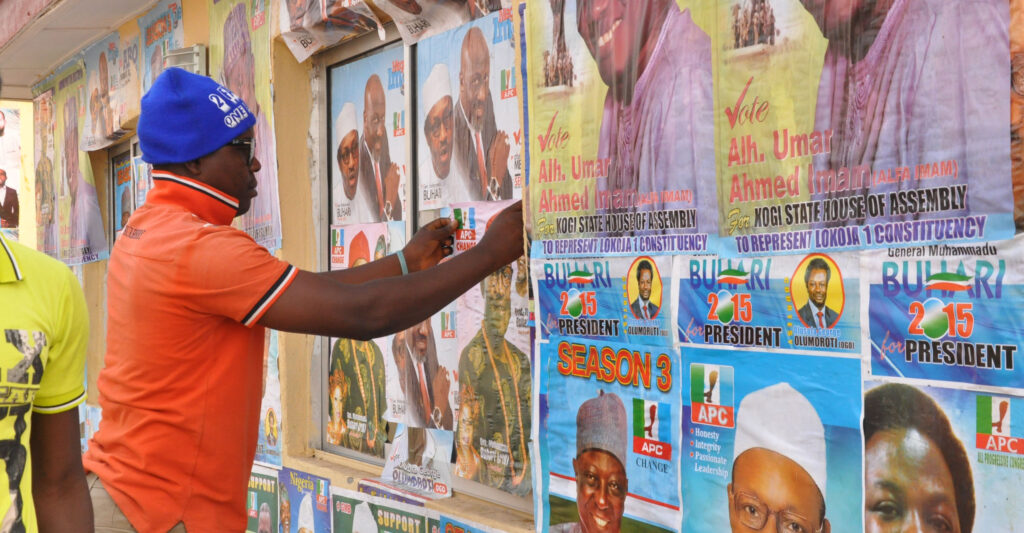 Vaalijulisteita liimataan ulos seinälle Nigeriassa.