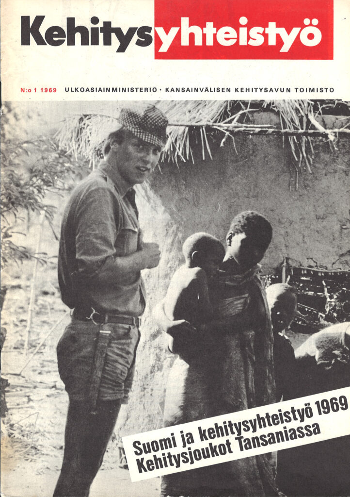 Lehdenkansi, jossa mustavalkoinen kuva valkoisesta miehestä ja afrikkalaisesta naisesta lapsi sylissään savimajan edustalla.